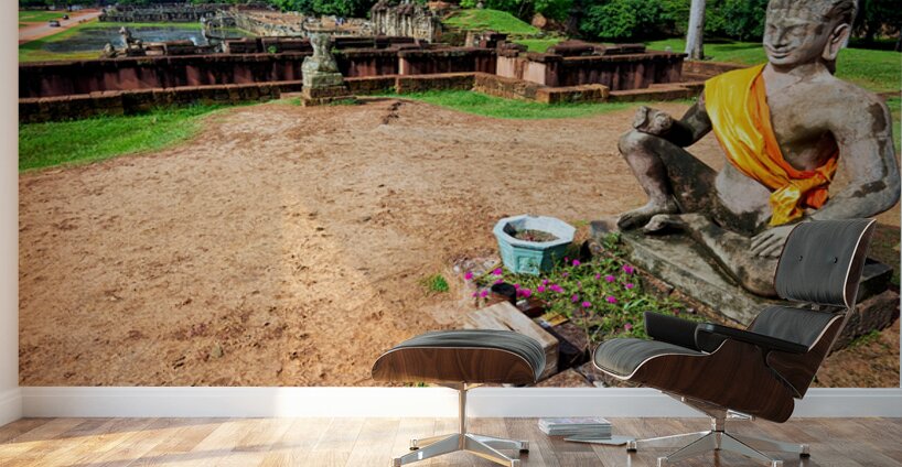 Ancient statue overlooks temple ruins amidst lush greenery. Wall Murals