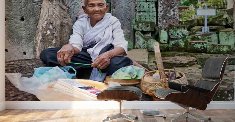 Elderly person selling goods at ancient temple ruins. Wall Murals