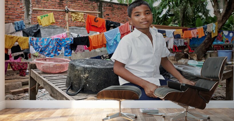 Boy with food tray clothes drying in background. Wall Murals