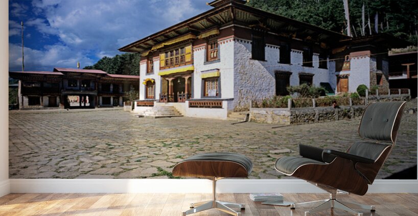 Traditional Bhutanese building with stone courtyard under a clou Wall Murals