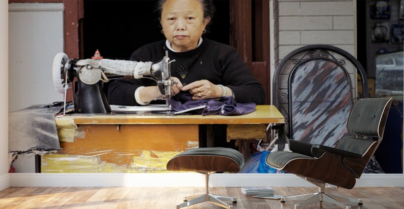 Elderly woman sews at machine in Shanghai China Wall Murals