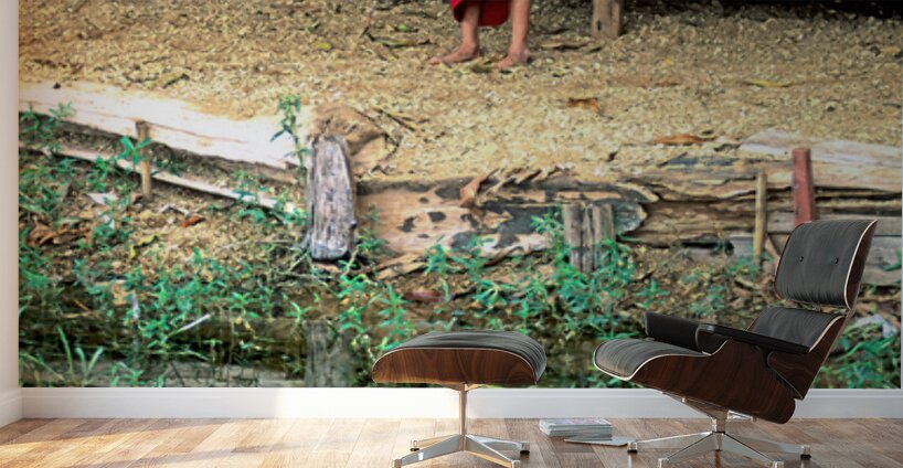 Young monk stands by water in Myanmar during daytime Wall Murals