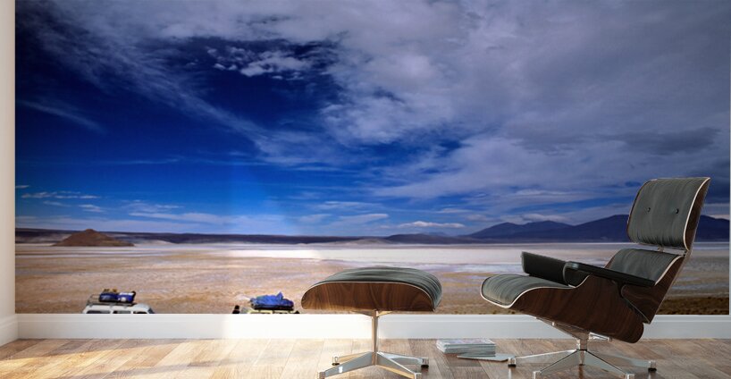 Vehicles traverse a vast arid salt flat landscape. Wall Murals
