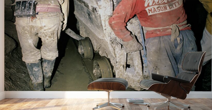 Miners pushing a loaded cart through a muddy underground mine. Wall Murals