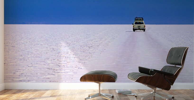 Van driving across vast white salt flat under blue sky. Wall Murals