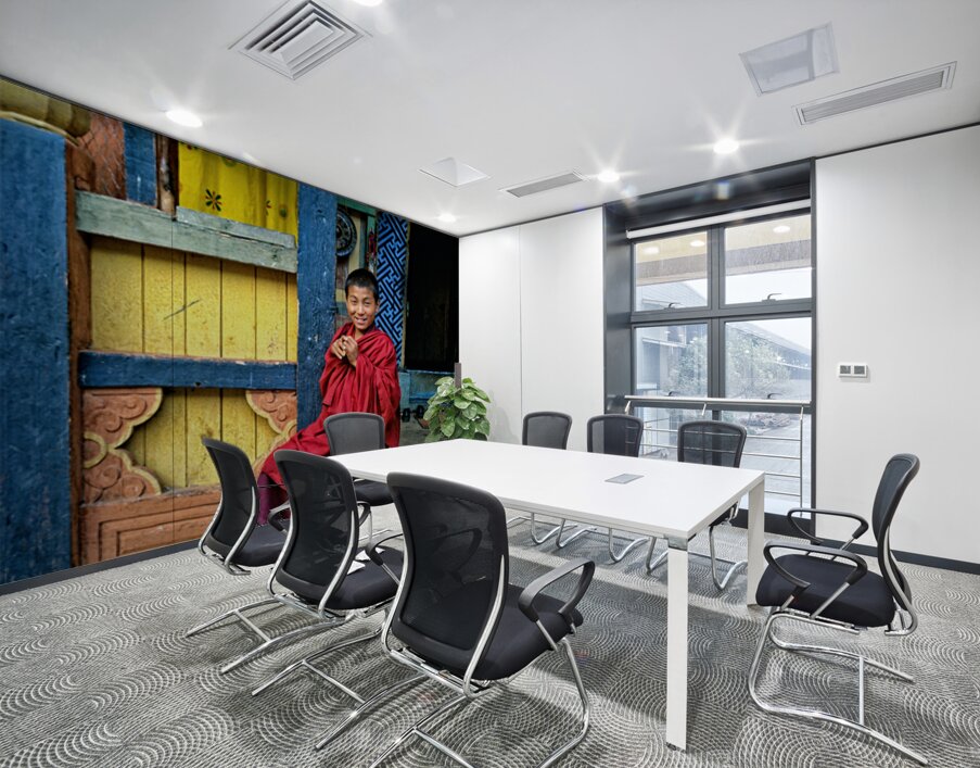 Smiling young monk in red robes at colorful traditional building Wall Printing
