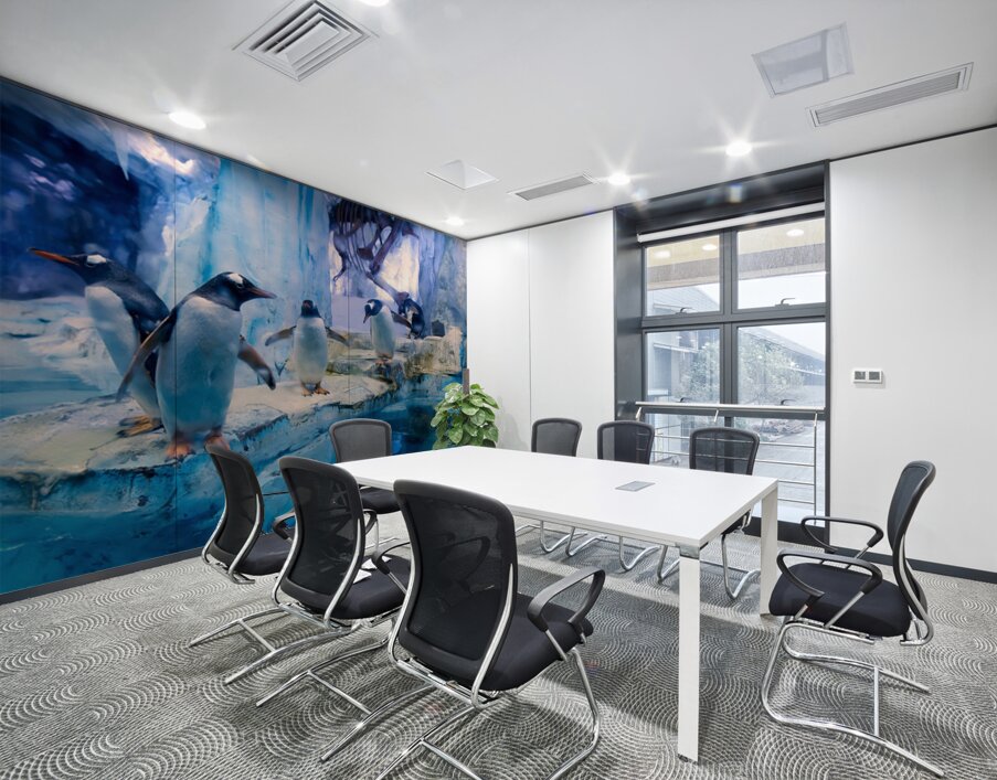 Penguins play on ice near water with a skeleton exhibit in Dubai Wall Printing