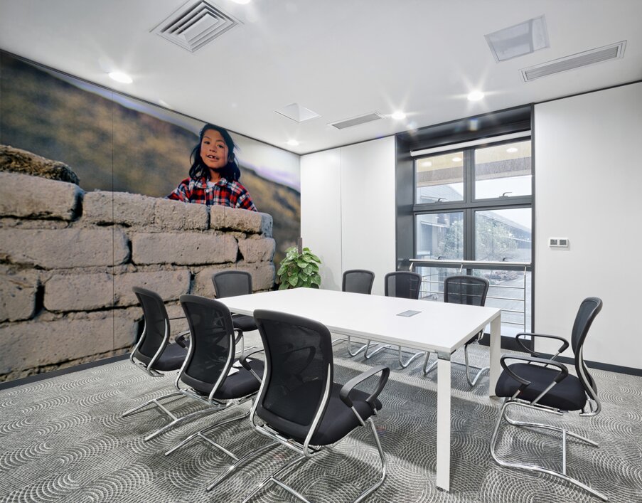 Young girl smiles over stone wall at sunset. Wall Printing