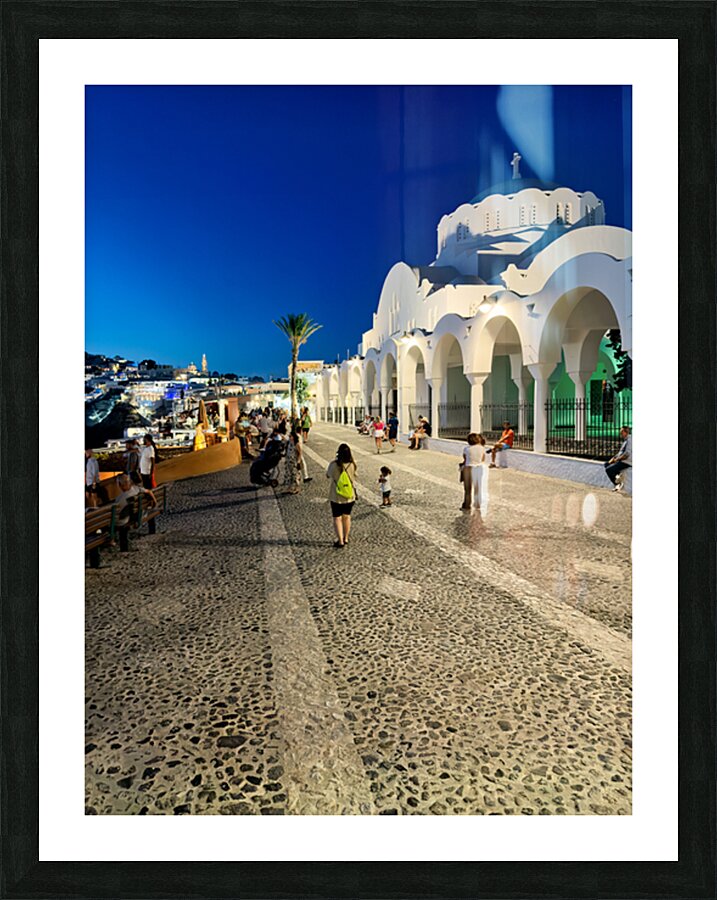 Santorinis iconic white church and bustling street at dusk. Picture Frame print