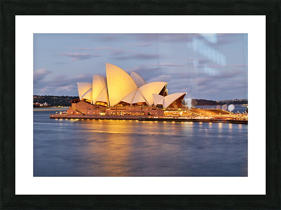 Sydney Opera House illuminated at dusk with harbor reflections. Picture Frame print