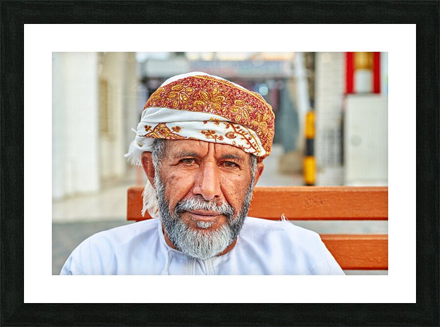 Man sitting on a bench in Muscat Oman during the day Picture Frame print