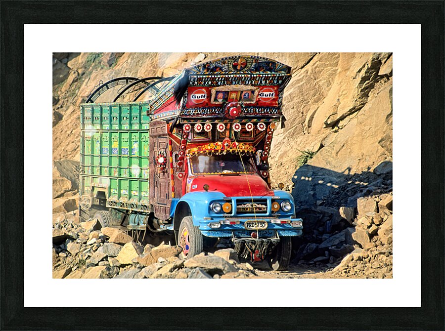 Trucks travel toward Shandur Pass in Pakistans rugged terrain Picture Frame print