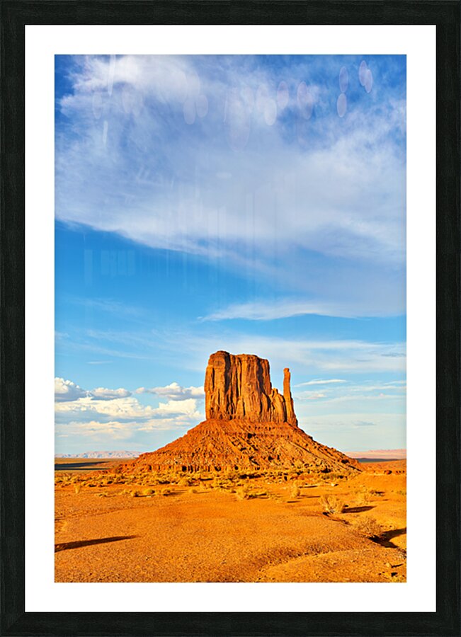 Monument Valley shows red rock formations under blue sky Picture Frame print