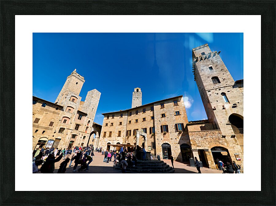 Visitors walk through Piazza della Cisterna in San Gimignano Picture Frame print