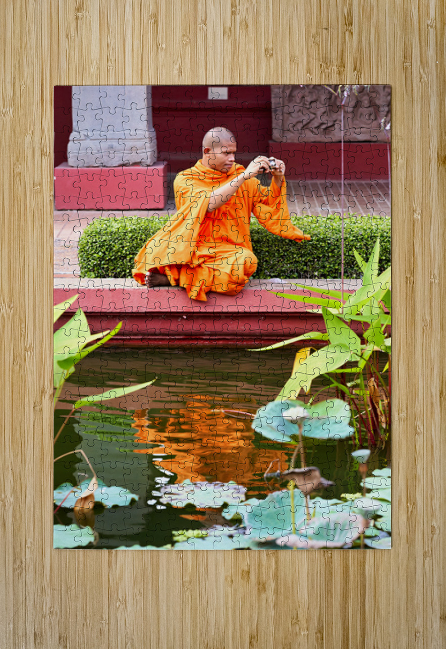 Monk in orange robes takes photo by a lotus pond. Marco Brivio Puzzle printing