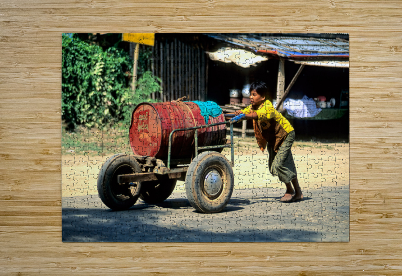Boy pushes a cart down the street in Myanmar during the day Marco Brivio Puzzle printing