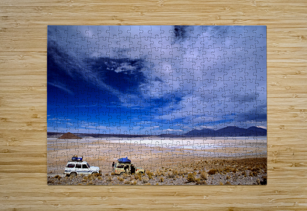 Vehicles traverse a vast arid salt flat landscape. Marco Brivio Puzzle printing