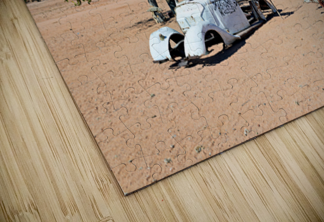 Classic car wreck in Namibias desert landscape near a structure Marco Brivio Puzzle