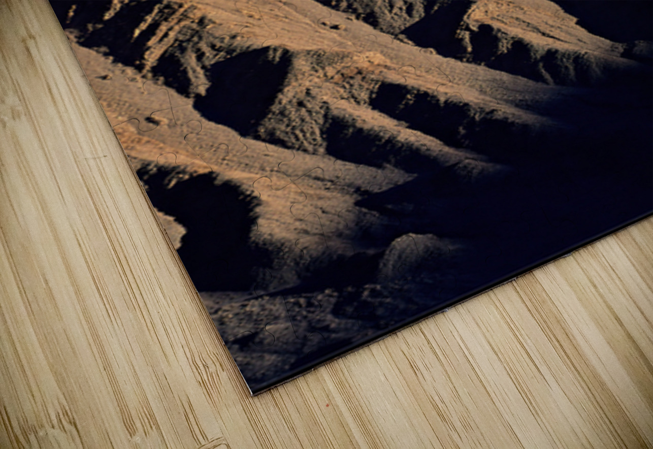 Hiker traverses a dramatic shadowed desert landscape. Marco Brivio Puzzle