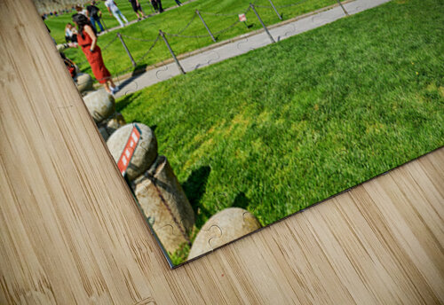 People walk in Piazza dei Miracoli admiring the Baptistry and Cathedral in Pisa. The sun shines on the historic buildings and green grass. Marco Brivio puzzle