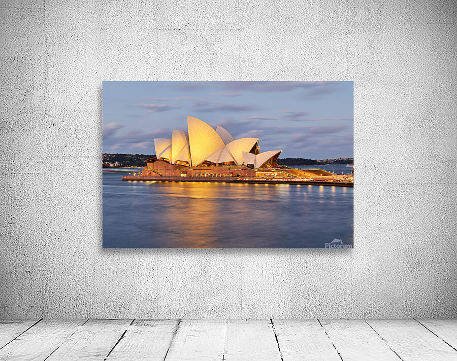 Sydney Opera House illuminated at dusk with harbor reflections. Wall Preview