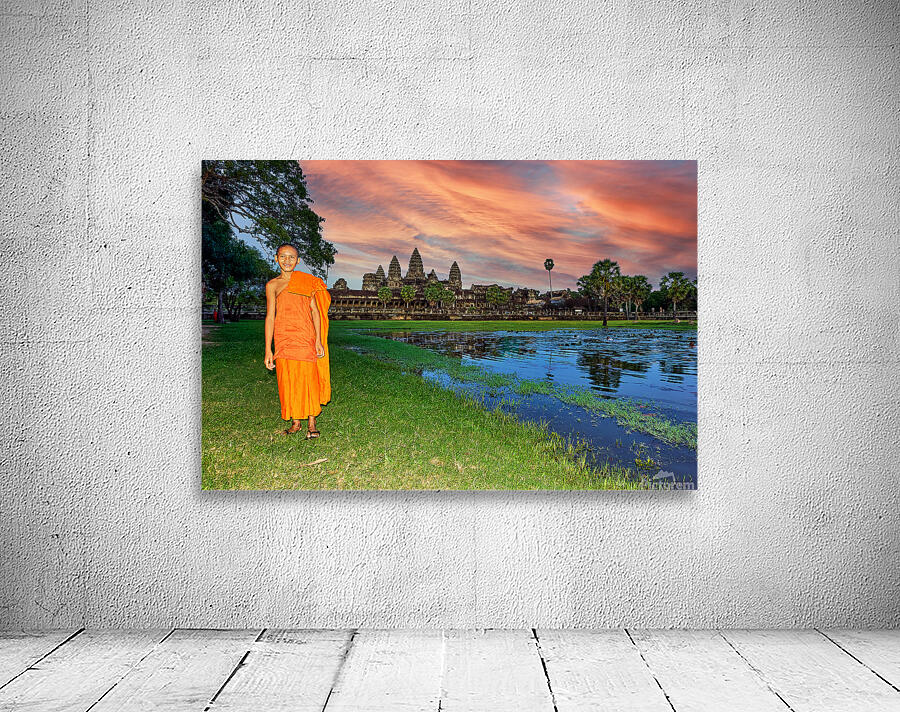 Monk stands by pond with Angkor Wat and sunset sky. Wall Preview