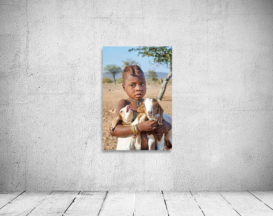 Child carries goats in Himba village of Namibia Kunene Region Wall Preview