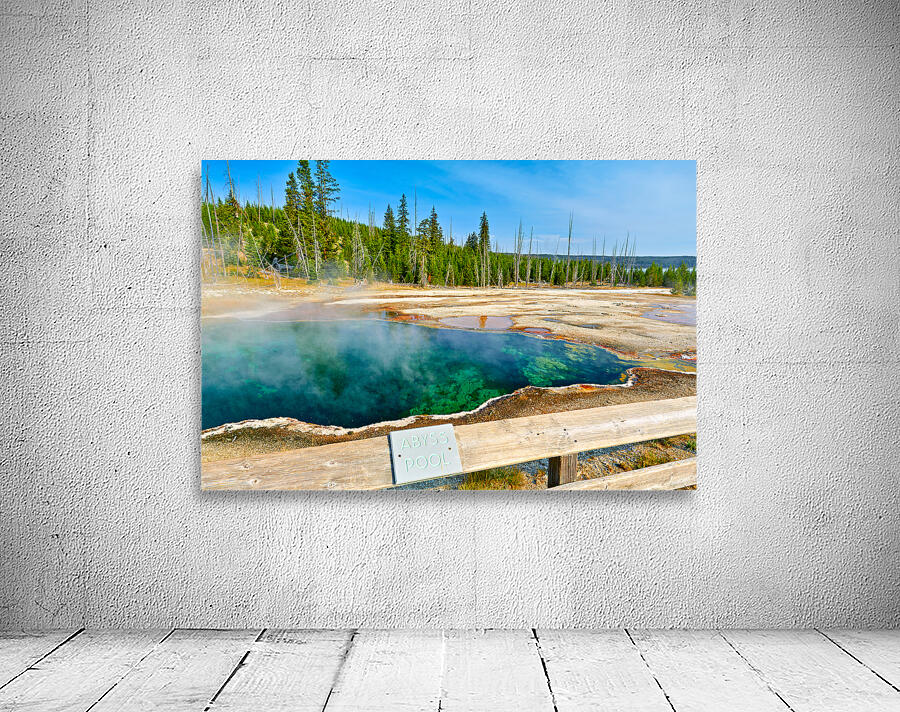 Tourists can see the deep blue Abyss Pool in Yellowstone National Park with steam rising from the hot springs during the warm afternoon. Wall Preview