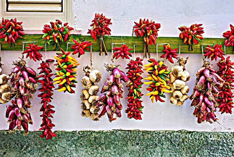 Vieste Gargano. Apulia Puglia Italy. Red chilishallot and garlic hanged to dry outside a house by Marco Brivio