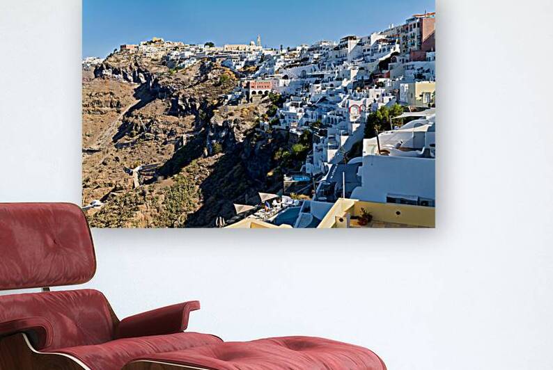 Santorinis white houses cascade down the volcanic cliff. by Marco Brivio