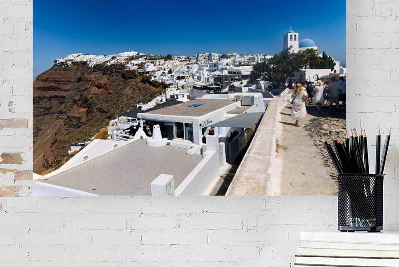 Santorini village on cliff with white buildings and blue domed c by Marco Brivio