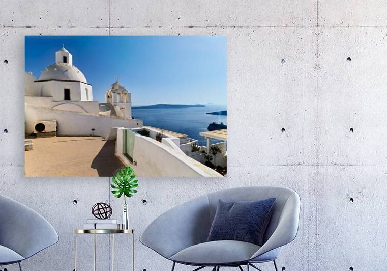 Santorinis iconic white churches overlook the Aegean Sea and ca by Marco Brivio