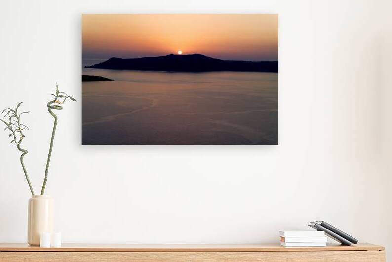 Golden sunset behind dark island calm ocean. by Marco Brivio