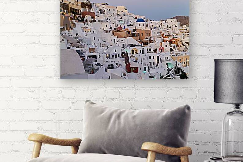 Santorinis iconic white buildings and blue domes on a hillside. by Marco Brivio