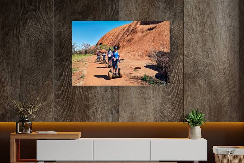 Tourists ride Segways near Uluru in Australia. by Marco Brivio