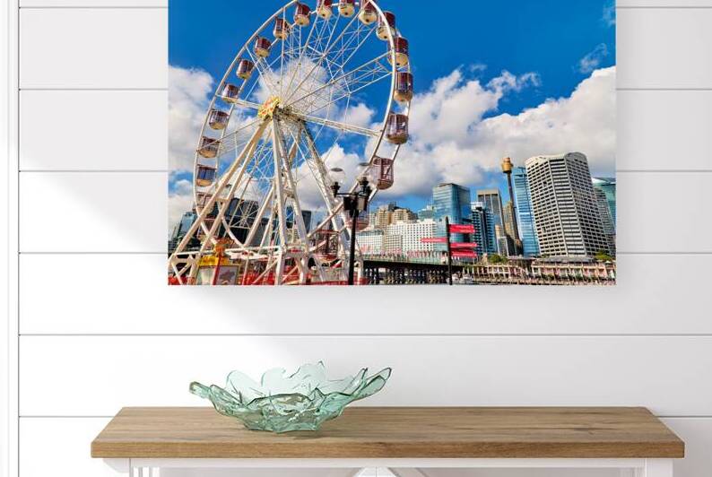 Sydney Ferris wheel with city skyline and blue sky. by Marco Brivio
