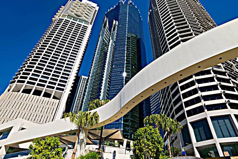 Woman walks on stairs in modern urban area with tall buildings by Marco Brivio