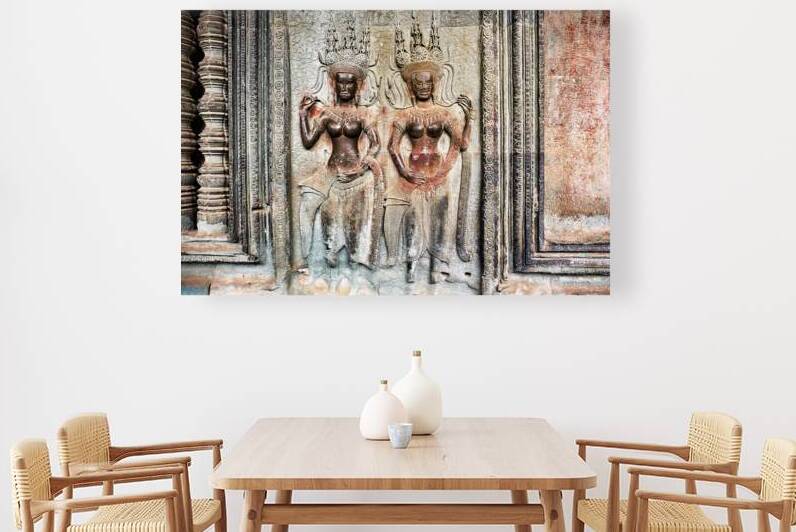 Two ornate Apsara carvings on an ancient temple wall. by Marco Brivio