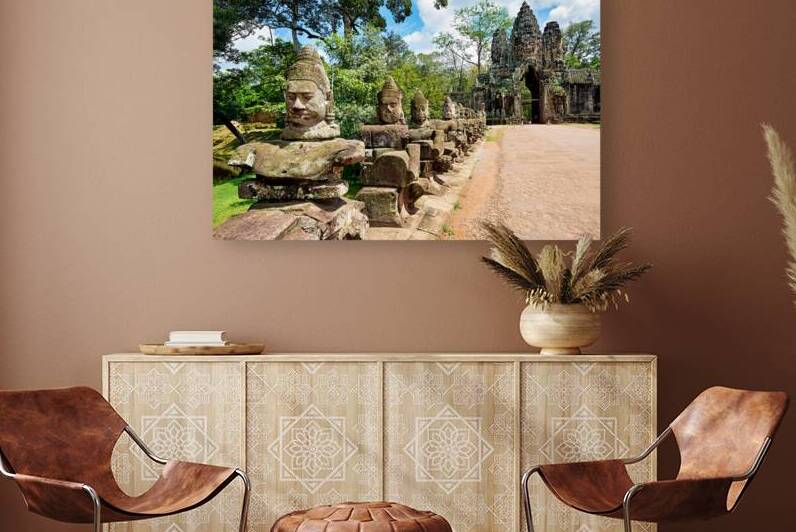 Ancient stone statues line path to Angkor Thom gate. by Marco Brivio