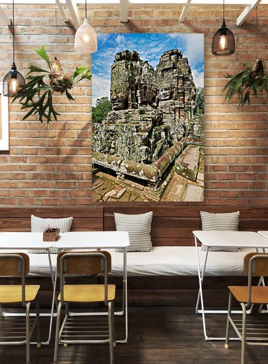 Ancient Khmer temple with carved stone faces. by Marco Brivio