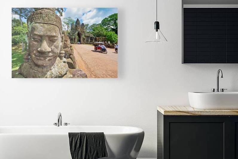 Ancient stone faces and grand temple gate at Angkor Thom. by Marco Brivio