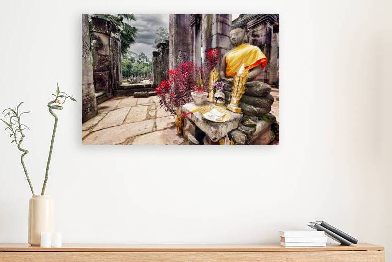 Ancient temple with Buddha statue offerings and red plants. by Marco Brivio