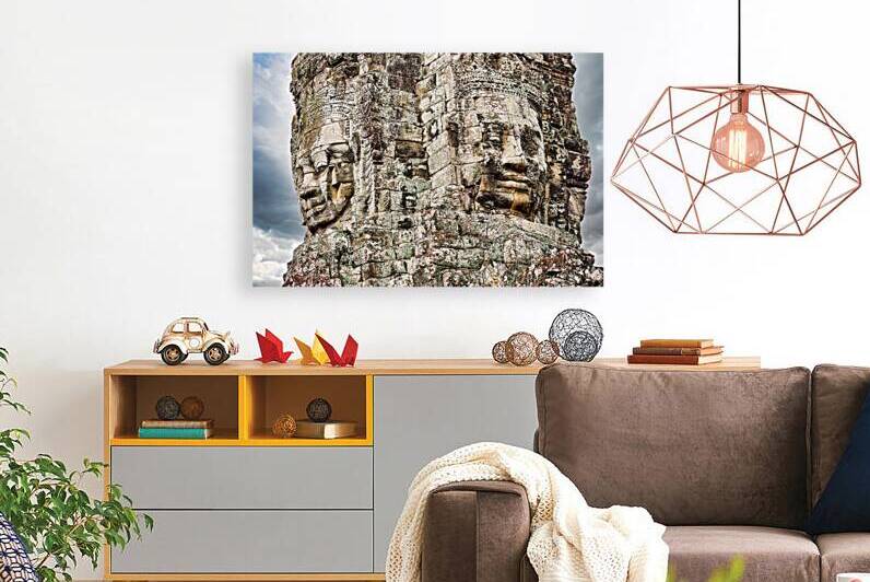 Ancient stone faces carved into Bayon Temple Cambodia. by Marco Brivio