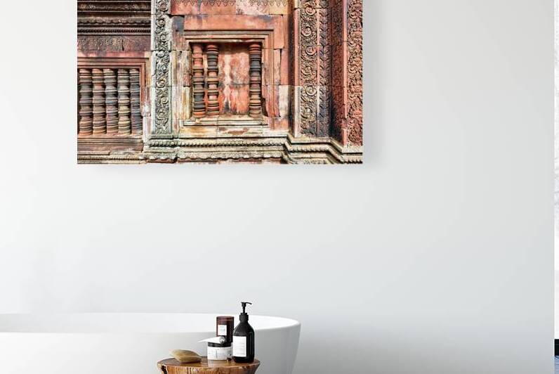 Ancient temple wall with intricate reddish stone carvings and co by Marco Brivio