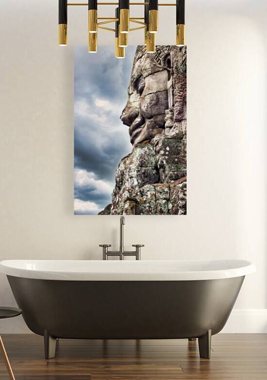 Ancient stone face carving against a dramatic cloudy sky. by Marco Brivio