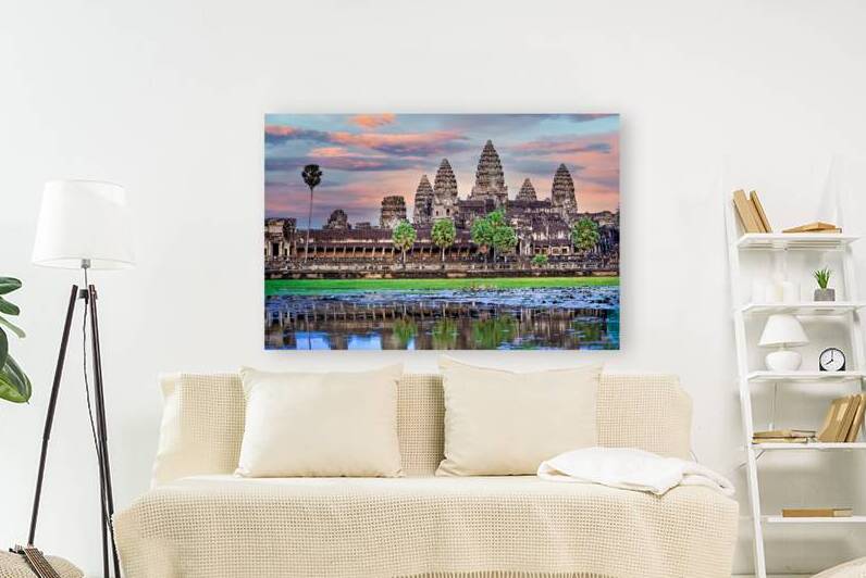 Angkor Wat temple at sunset reflected in a lotus pond. by Marco Brivio