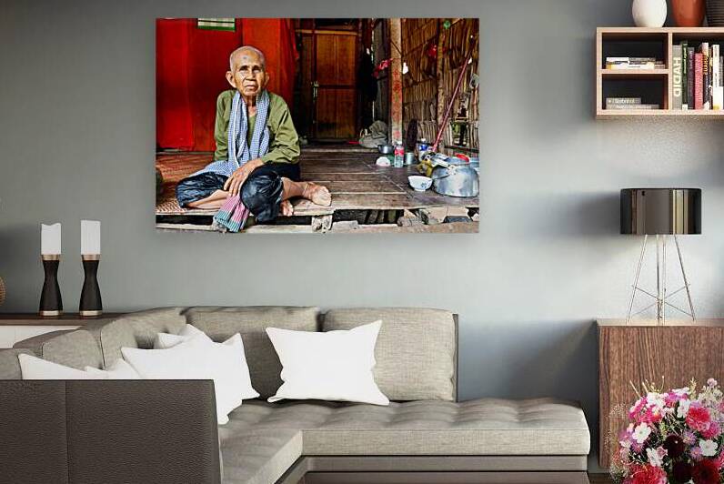 Elderly person sitting on floor in rustic dwelling. by Marco Brivio