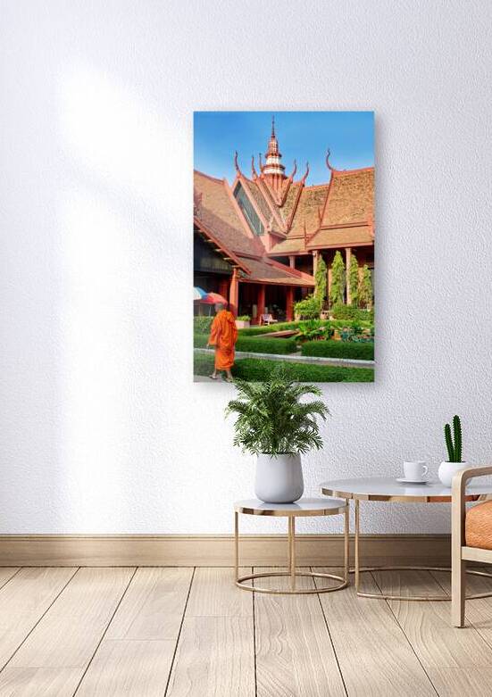 Monk walks through traditional Cambodian temple garden. by Marco Brivio