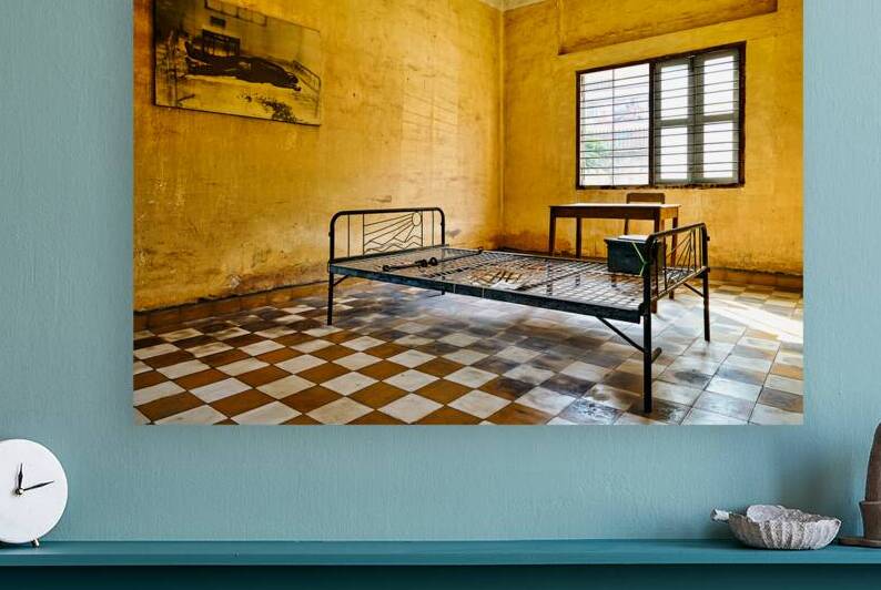 Tuol Sleng Genocide Museum cell with bed and victim photo. by Marco Brivio