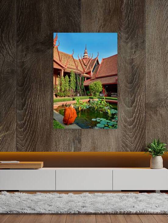 Monk by pond at traditional Cambodian temple. by Marco Brivio